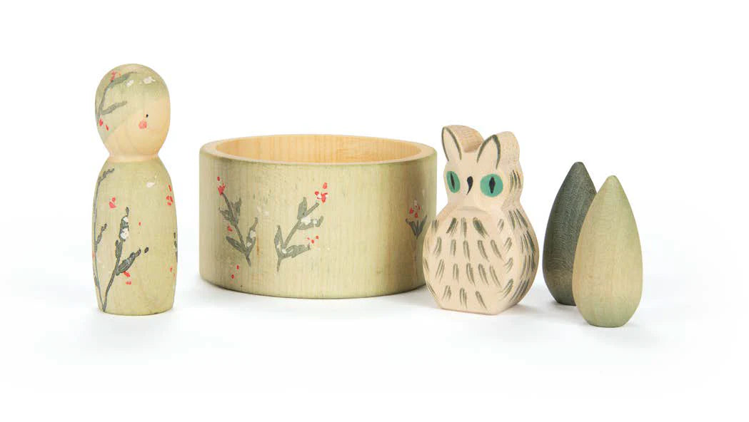 Set of wooden toys including a rabbit, owl, and leaf on a white background